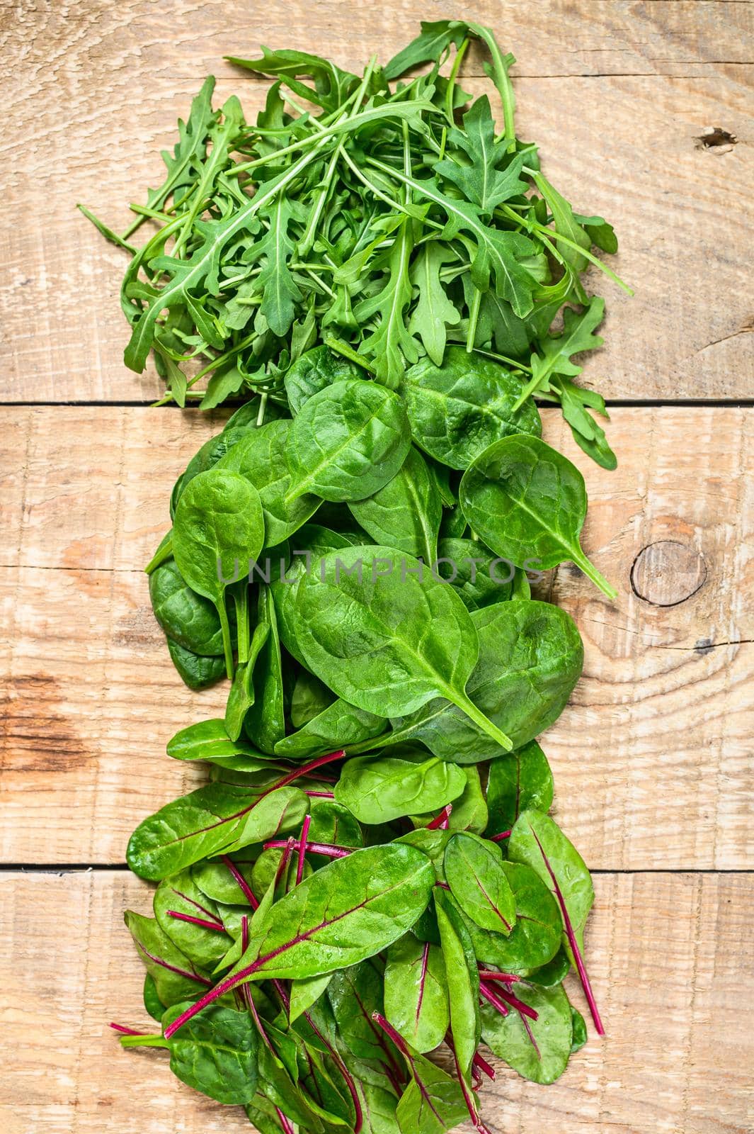 Mix Salad leafs, Arugula, Spinach and swiis Chard. Wooden background. Top view by Composter