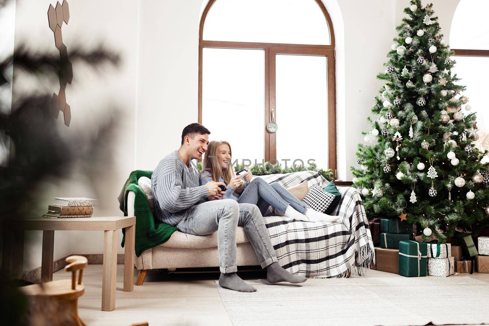 Sweet couple embracing on sofa at home during christmas holidays