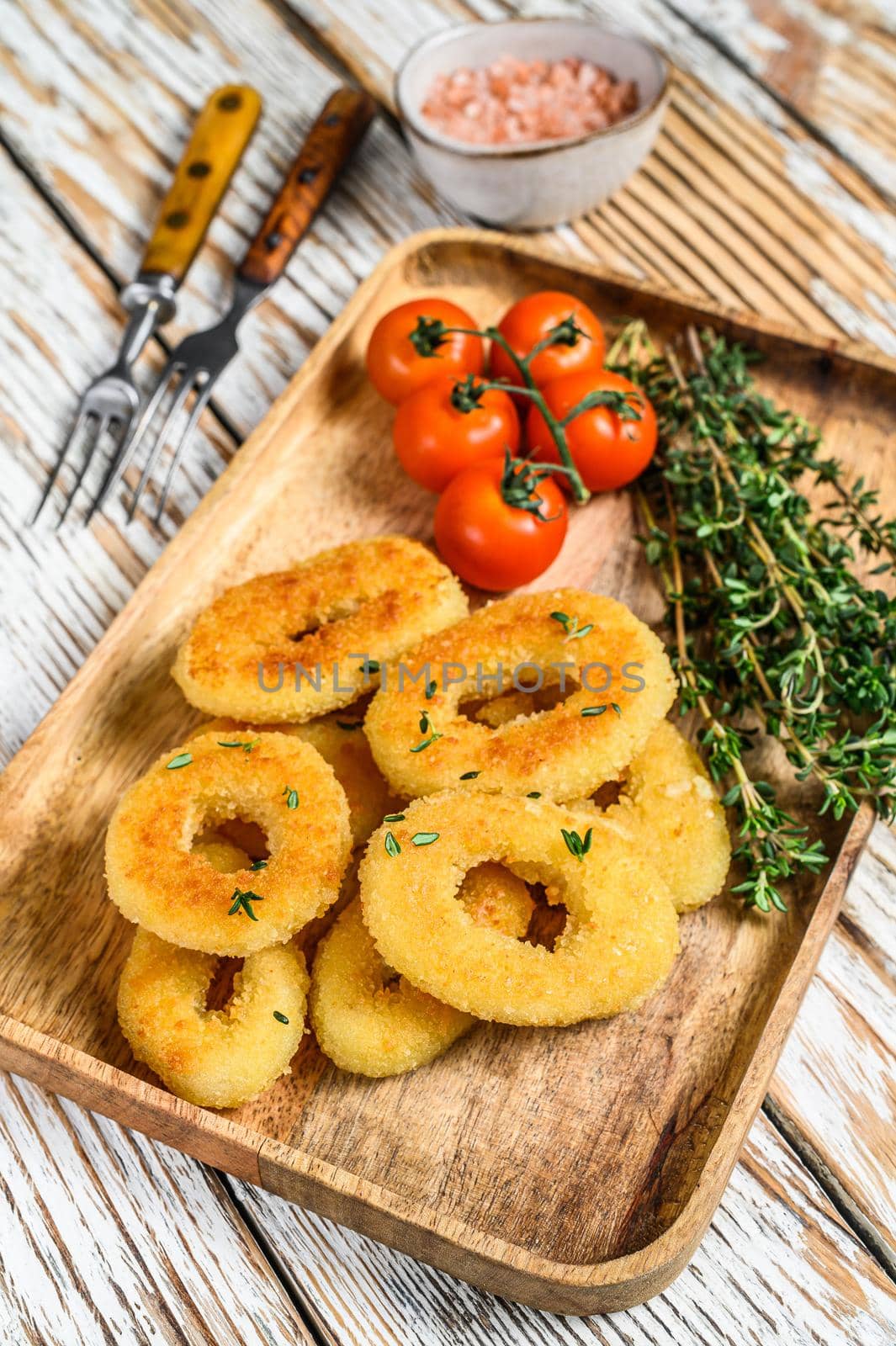 Deep fried crispy onion rings breaded. White wooden background. Top view by Composter