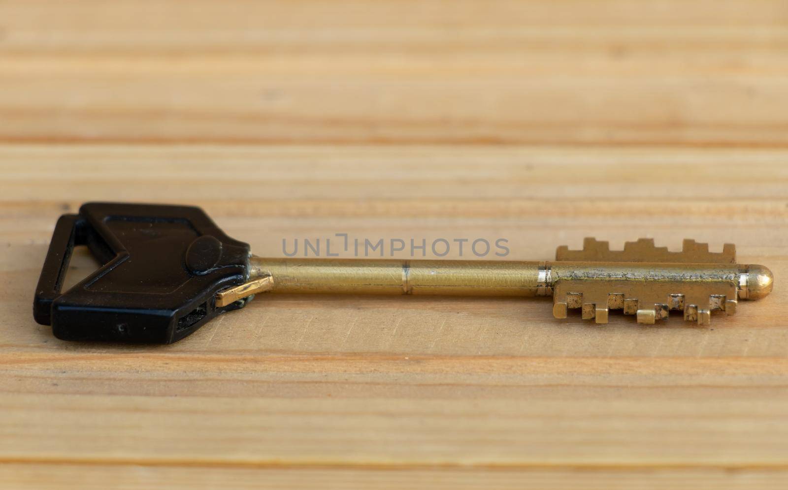 A key on a wooden background close up by Mindru