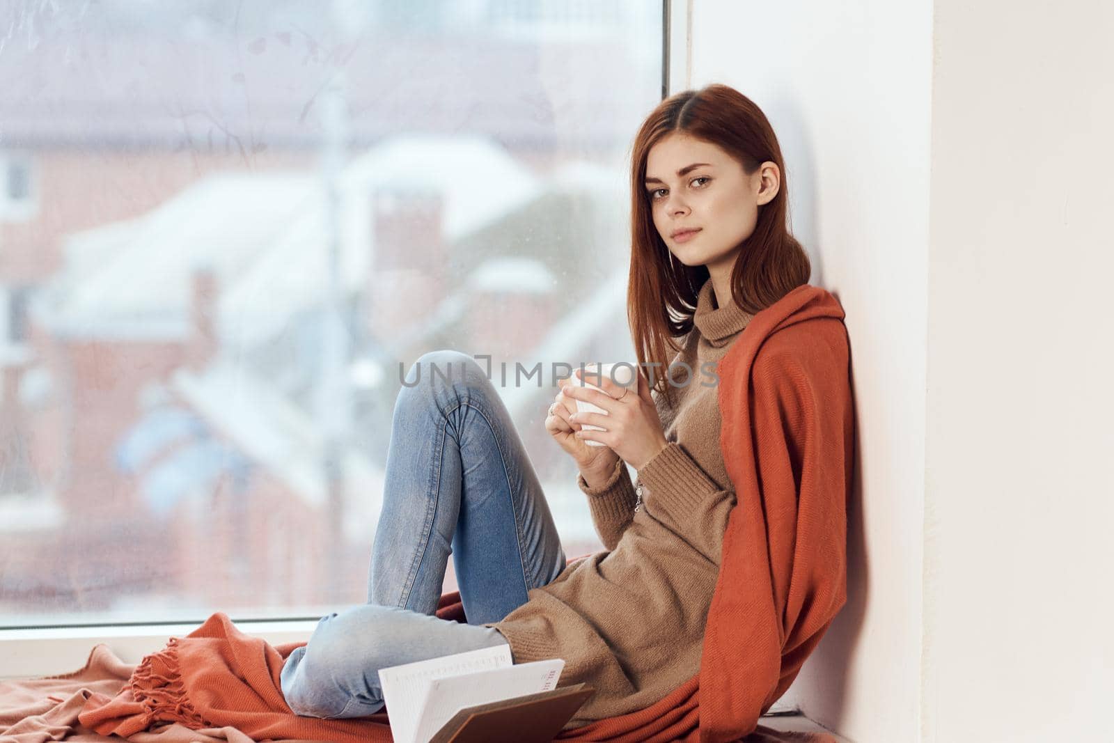 woman looking out the window on the windowsill Comfort weekend rest. High quality photo