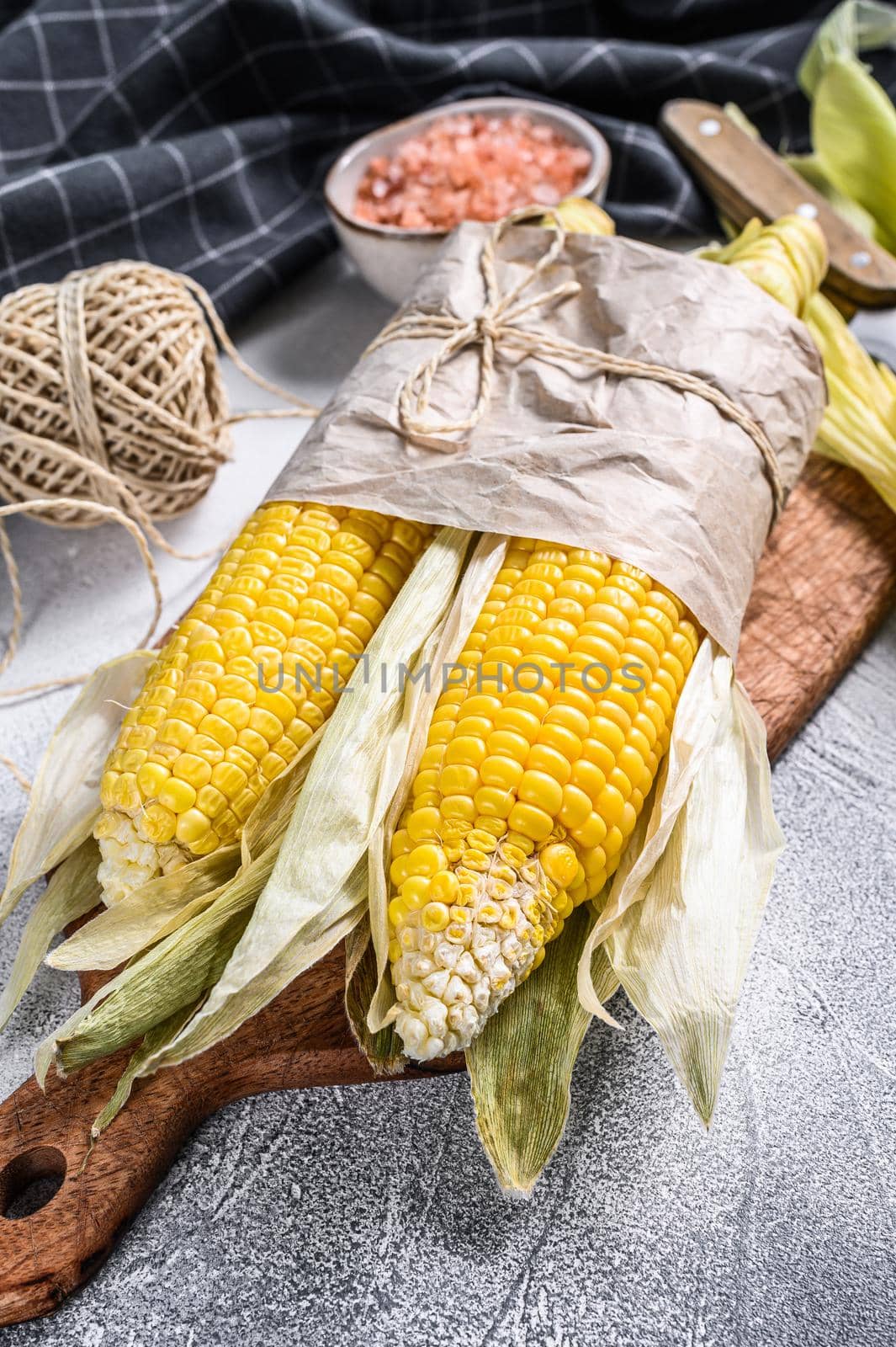 Fresh harvested corn cob on farmer market, local vegetables. Gray background. Top view by Composter