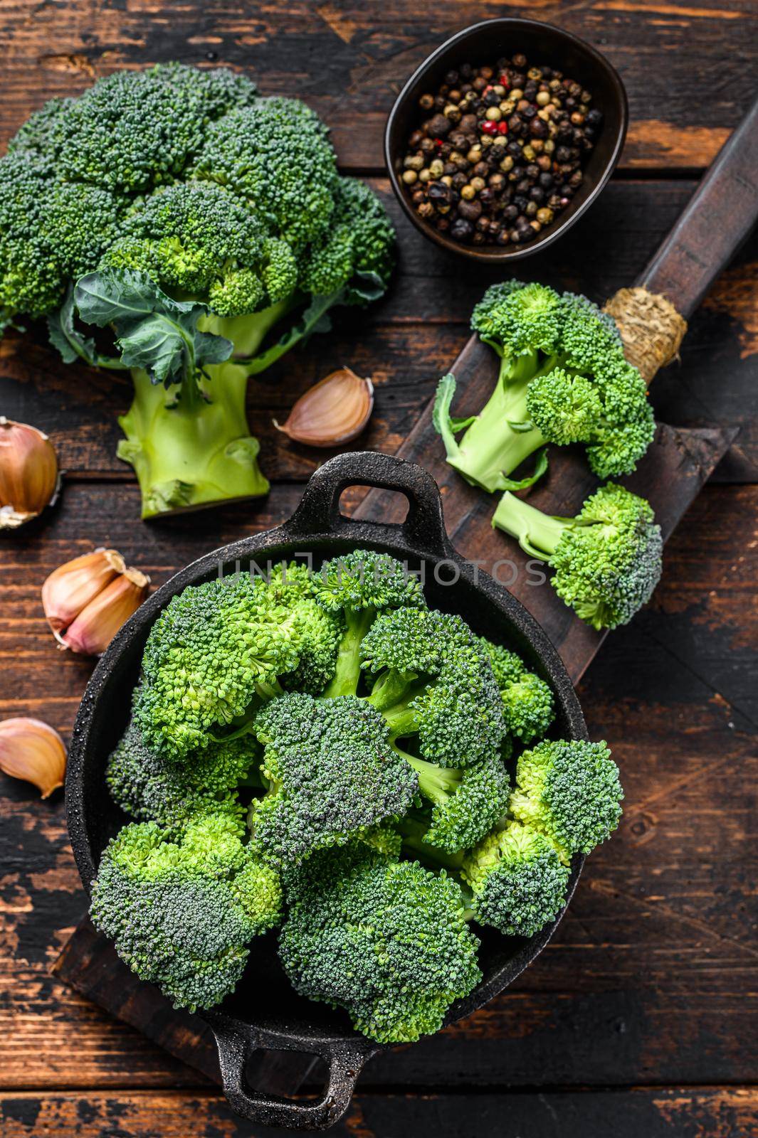 Raw green broccoli cabbage in a colander. Dark wooden background. Top view by Composter