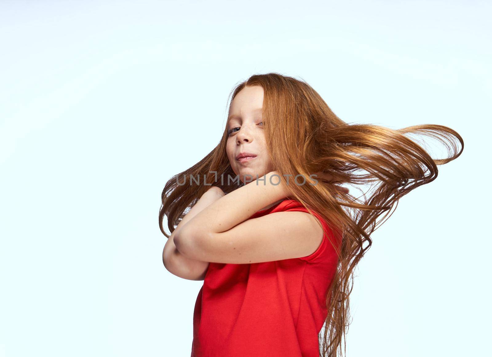 girl with red hair posing red t-shirt childhood. High quality photo
