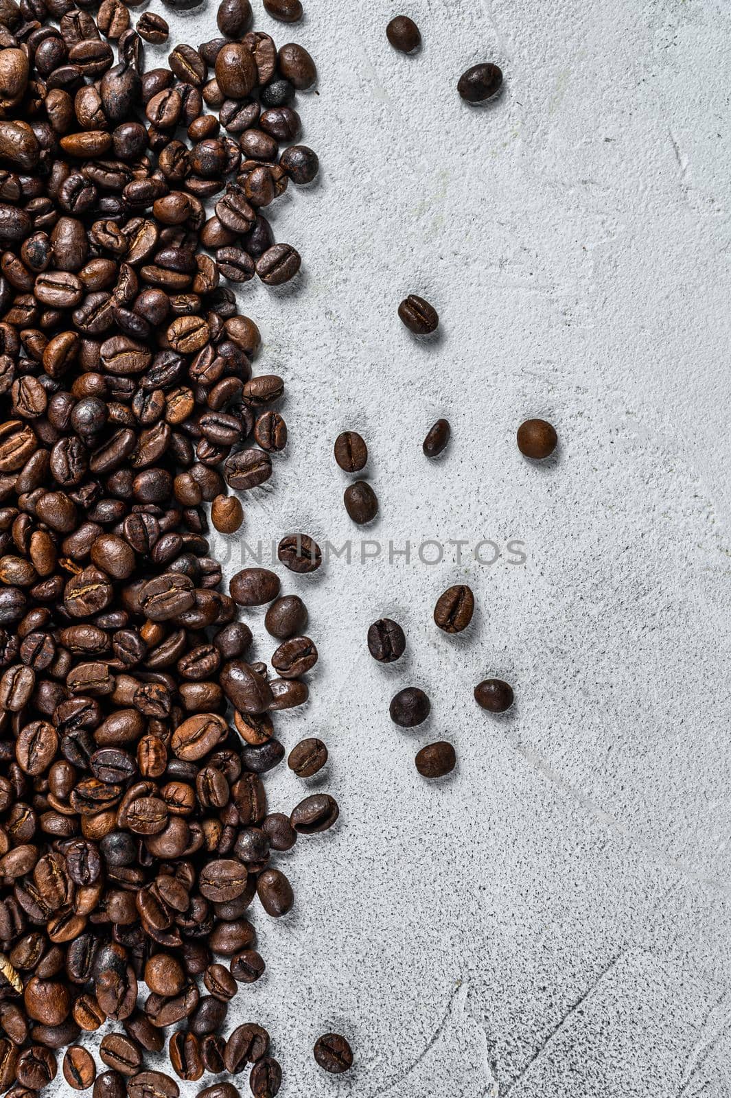 Roasted coffee beans on rustic table. White background. Top view. Copy space by Composter