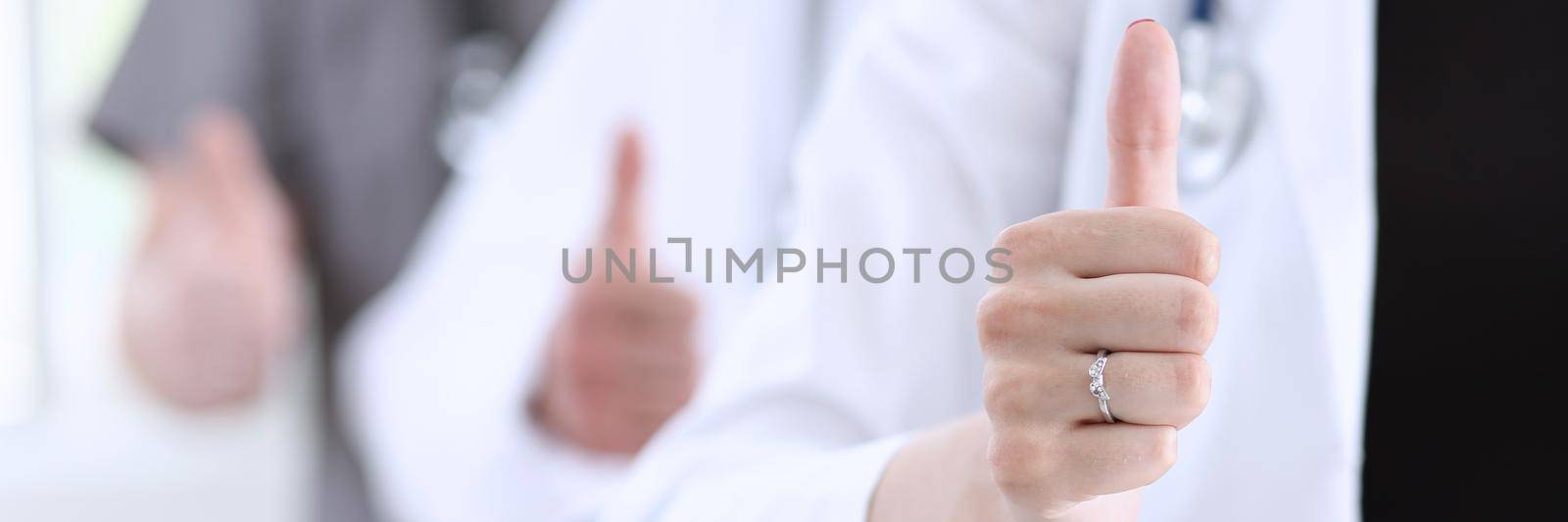 Group of doctor hands show OK or approval sign with thumb up closeup. High level service, best treatment, 911, healthy lifestyle, satisfied patient, therapeutist consultation, physical concept