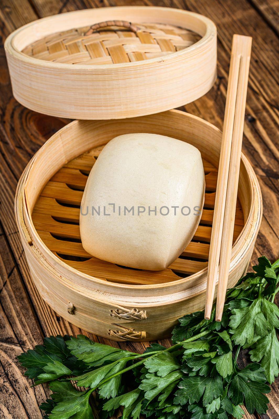 Chinese Steamed Buns in traditional bamboo steamer. Wooden background. Top view by Composter