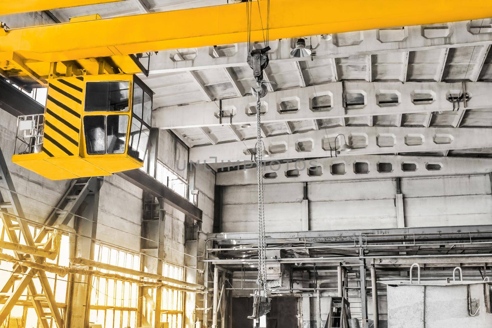 Overhead crane hoist equipment in an industrial plant transports an iron rail on lifting chain by AYDO8