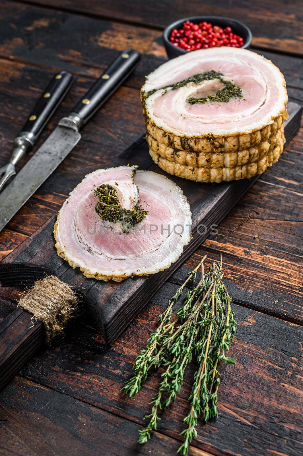 Sliced Italian pancetta on a cutting board. Dark Wooden background. Top view. Copy space by Composter