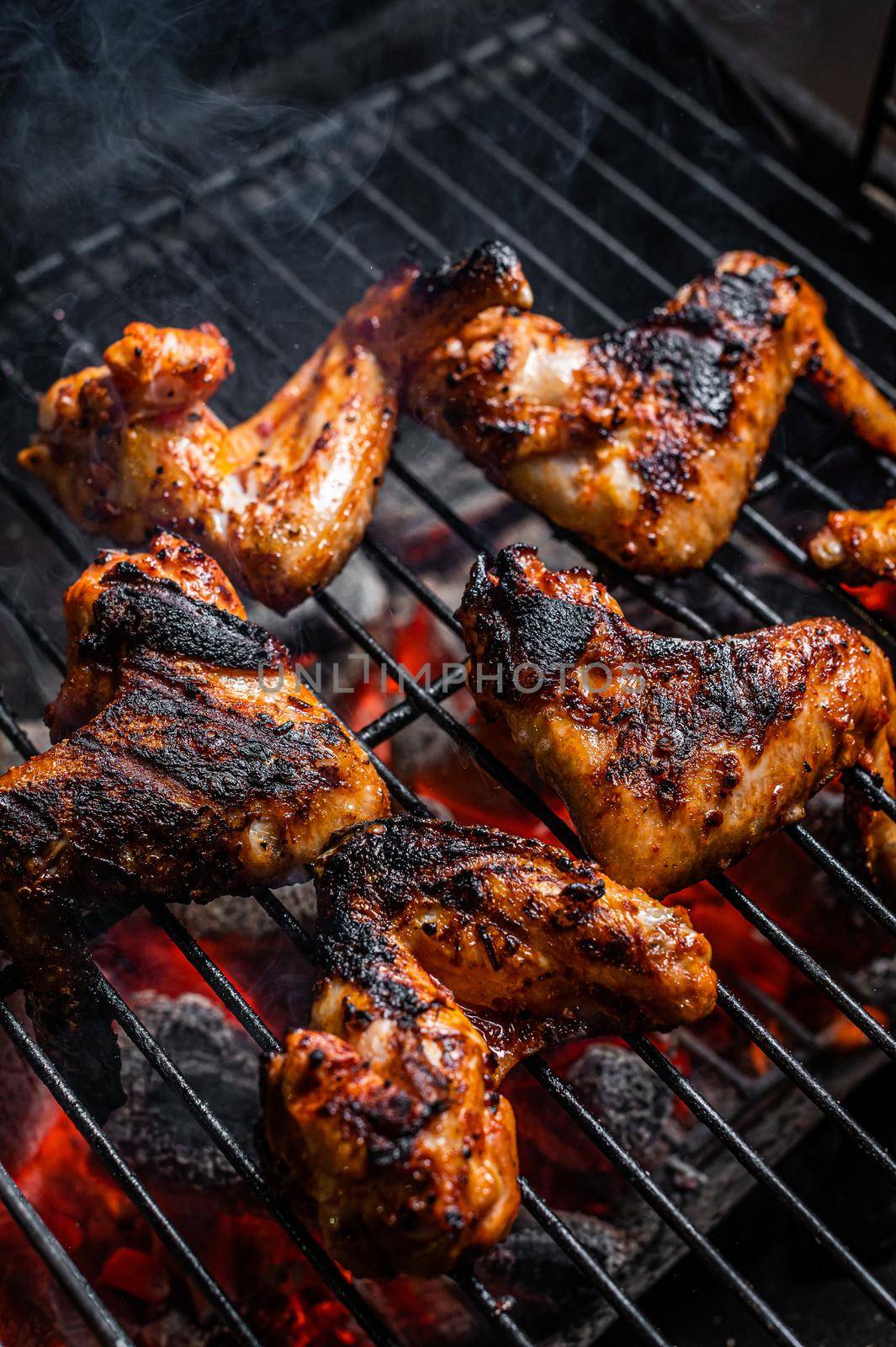 Chicken wings on barbecue, outdoor BBQ grill with fire. Top view by Composter