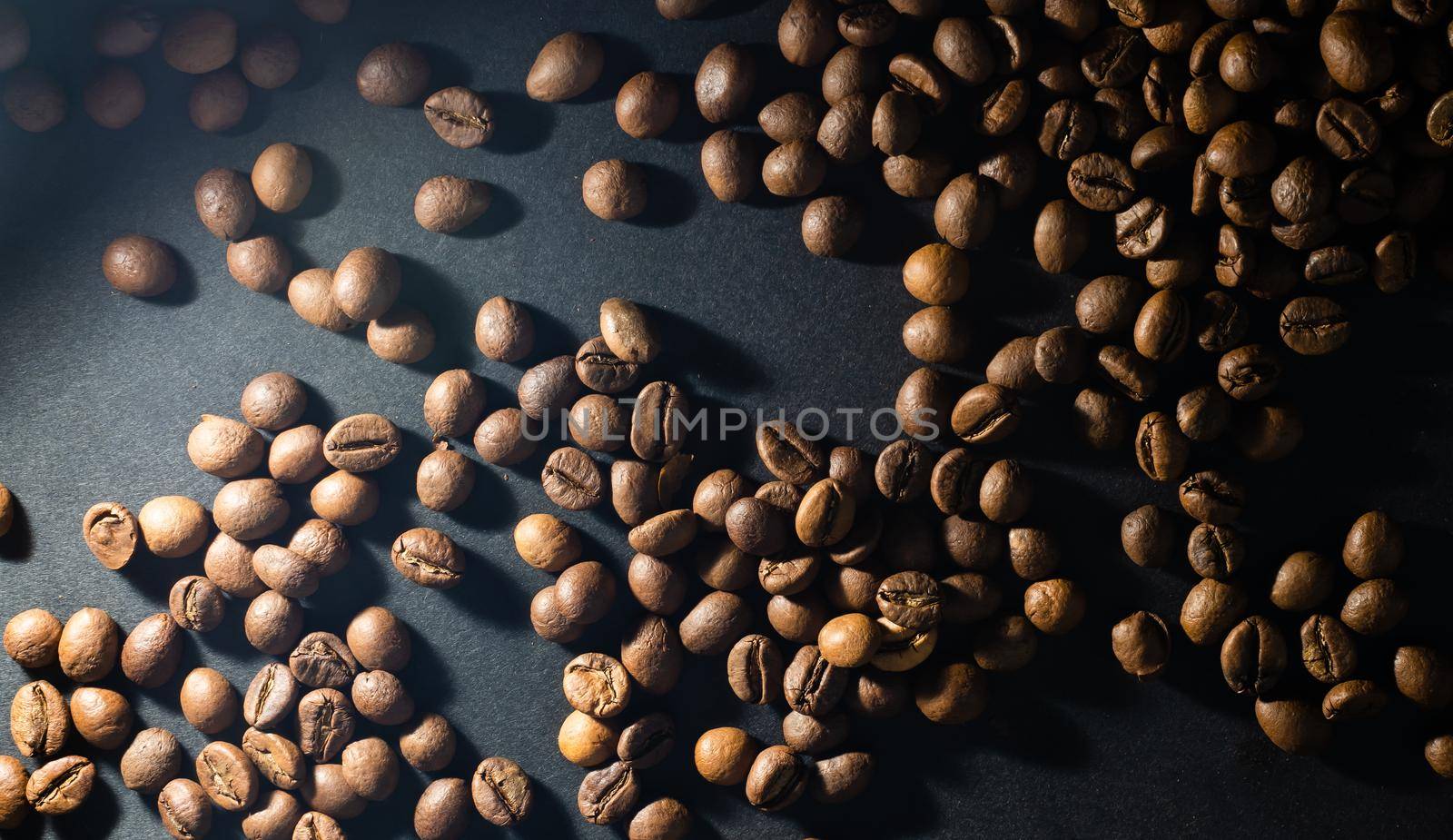 Flying coffee beans over dark.