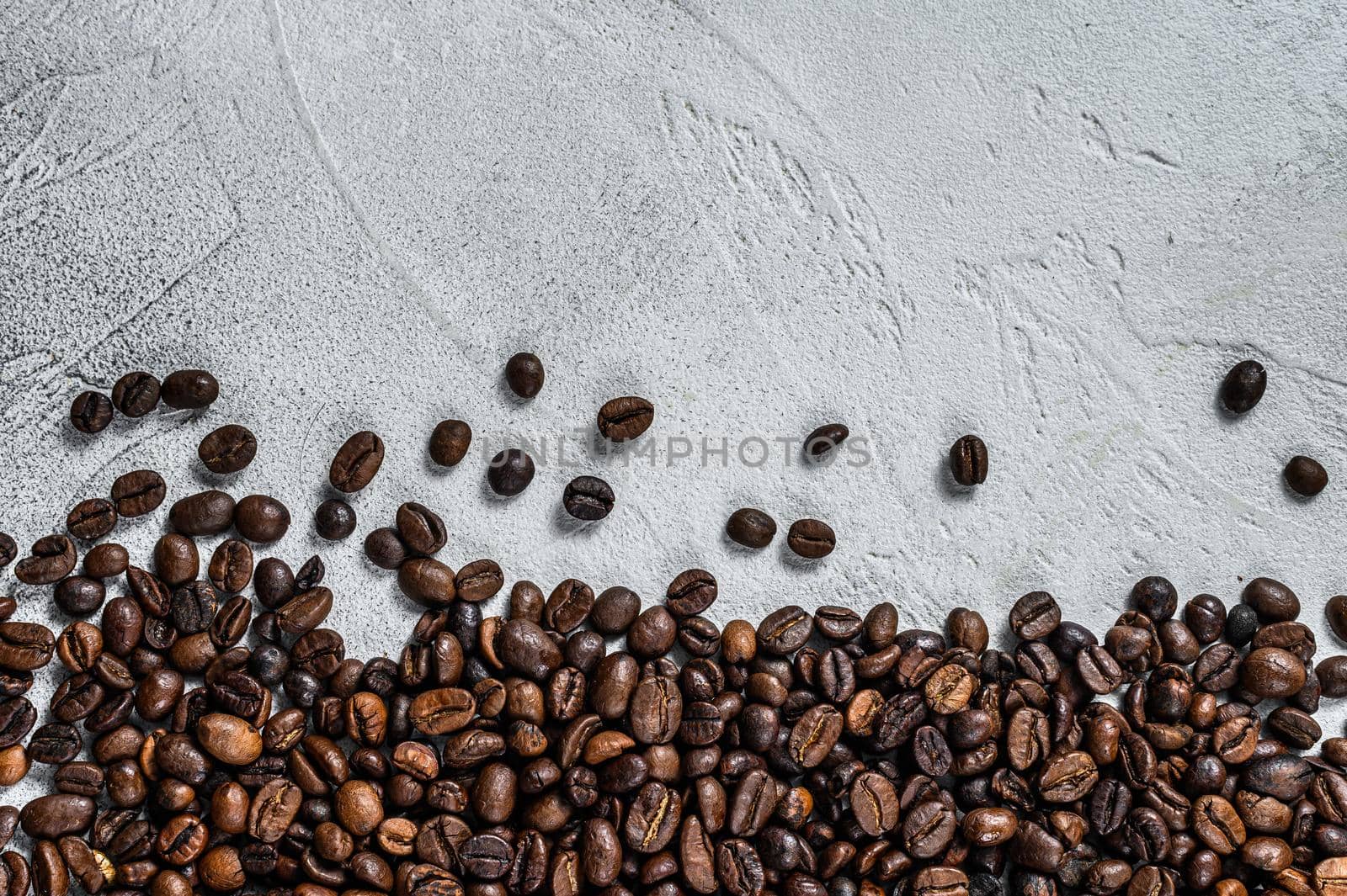 Roasted coffee beans on rustic table. White background. Top view. Copy space by Composter