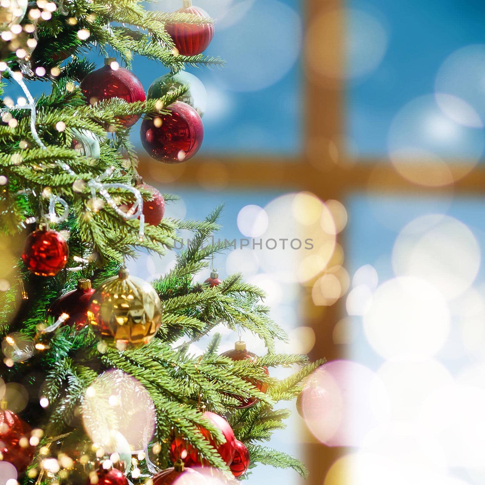 Closeup of red bauble hanging from a decorated Christmas tree by Andelov13