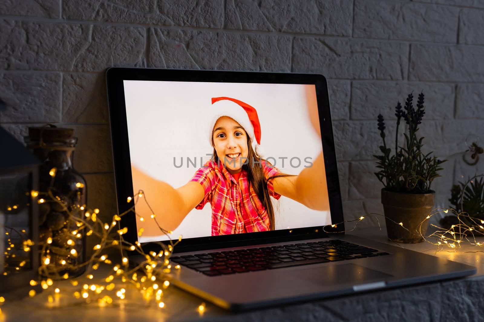 Image of open laptop family and christmas on wooden table in front of christmas tree background.