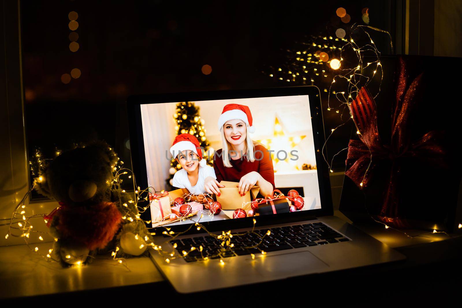 Upper view of modern family sitting on couch in the modern living room at Christmas on laptop.