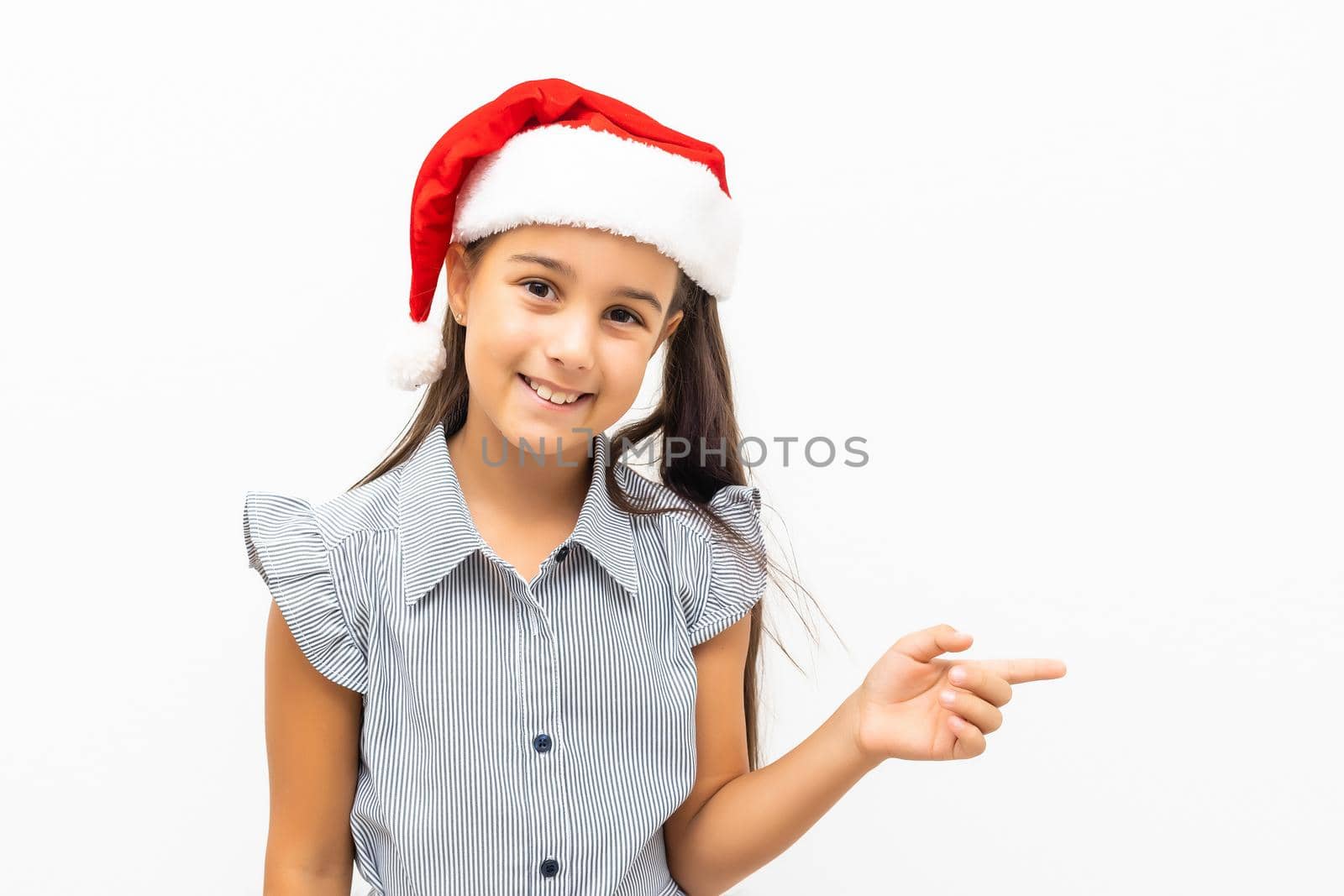 Cute little girl in Santa hat on white background.