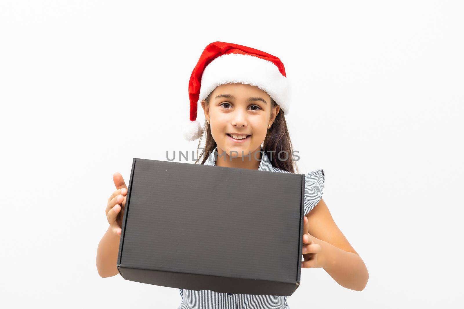 Happy girl holding gift box on white wall background.