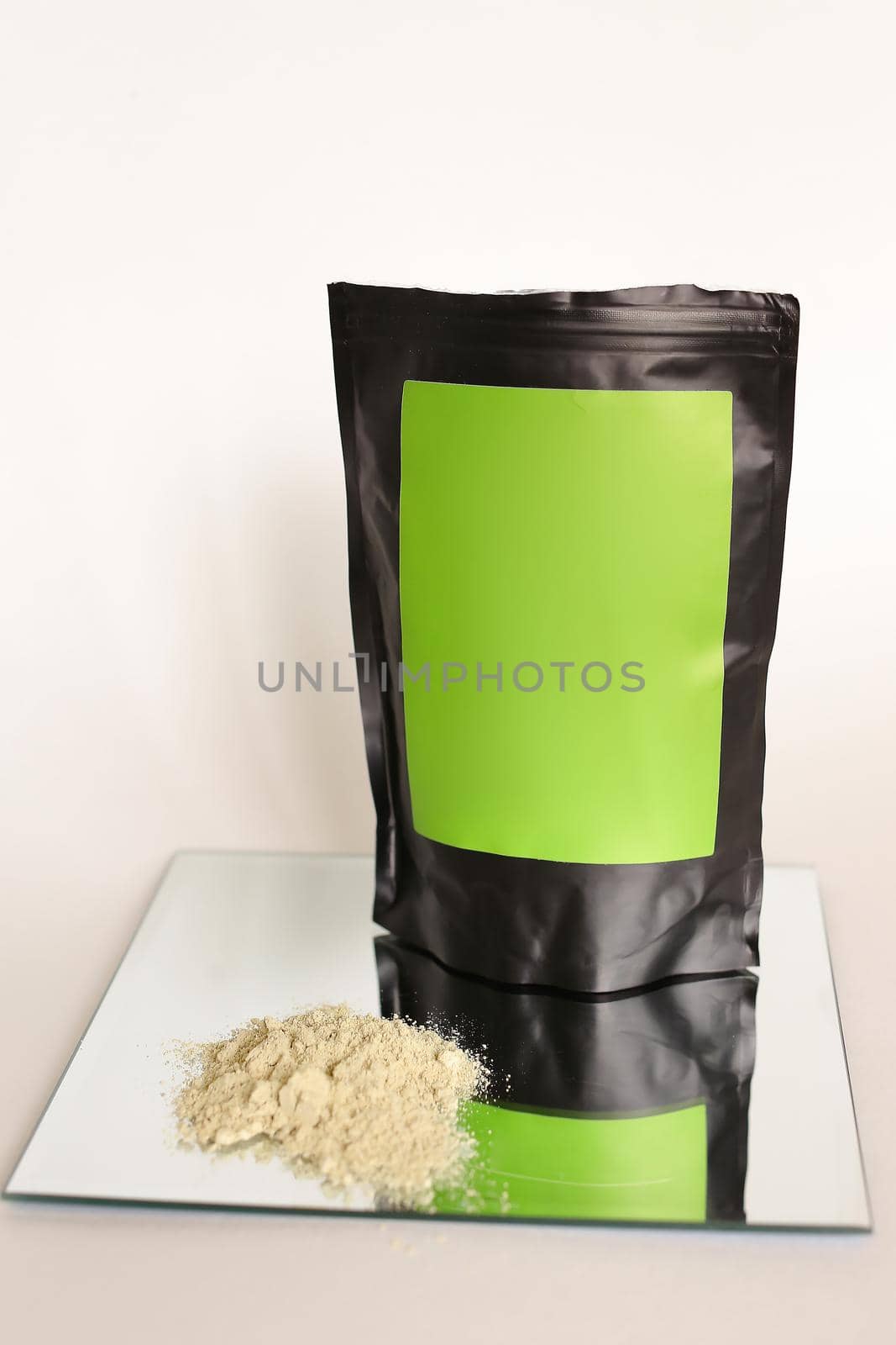Close up black doy pack with cosmetic product and green space for your brand, powder on glass.. Concept of cluelty free, organic, kosher flour and organic cosmetics online shop.