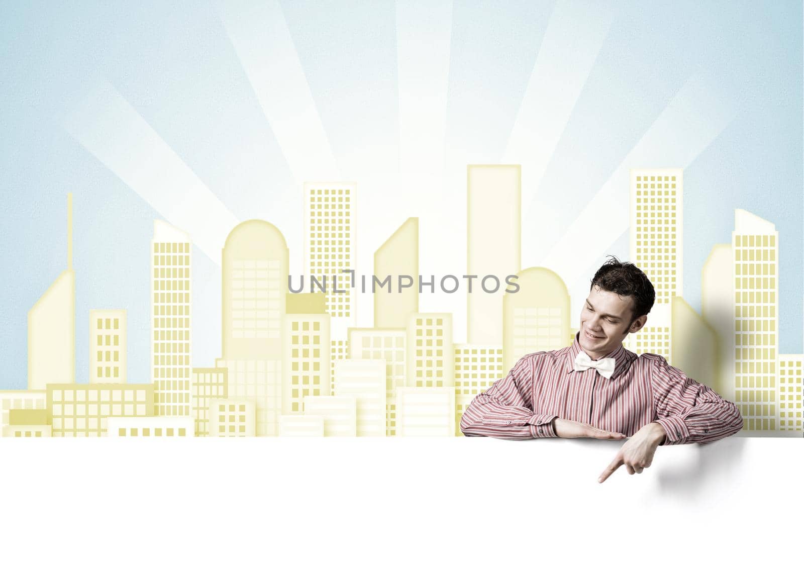 Young funny guy in checked shirt pointing with finger at blank banner