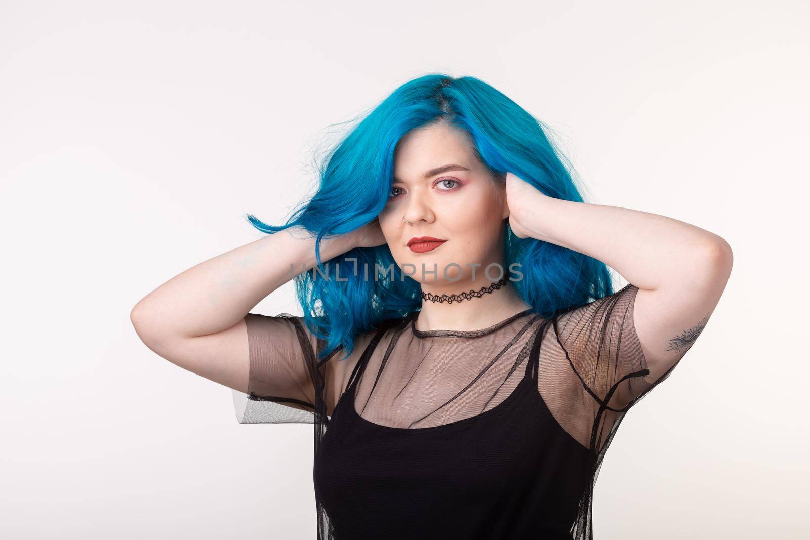 People and fashion concept - Beautiful woman with blue hair posing over white background.