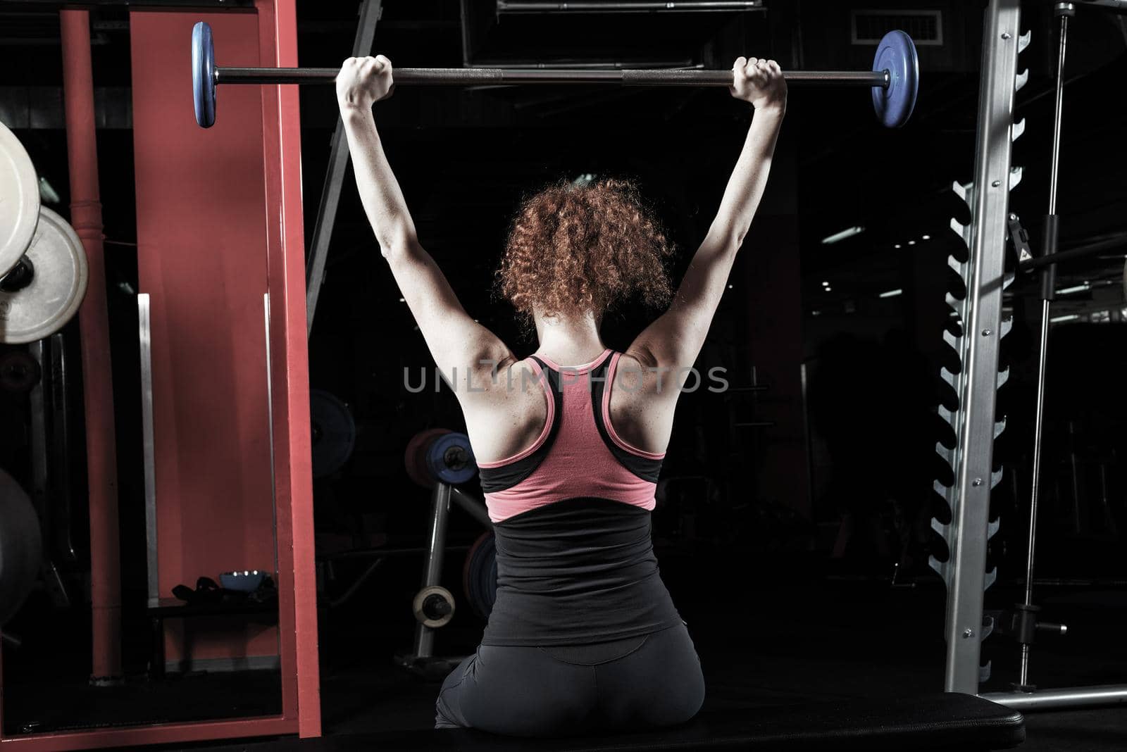 Woman bodybuilder engaged with a barbell in the gym. Healthy lifestyle.