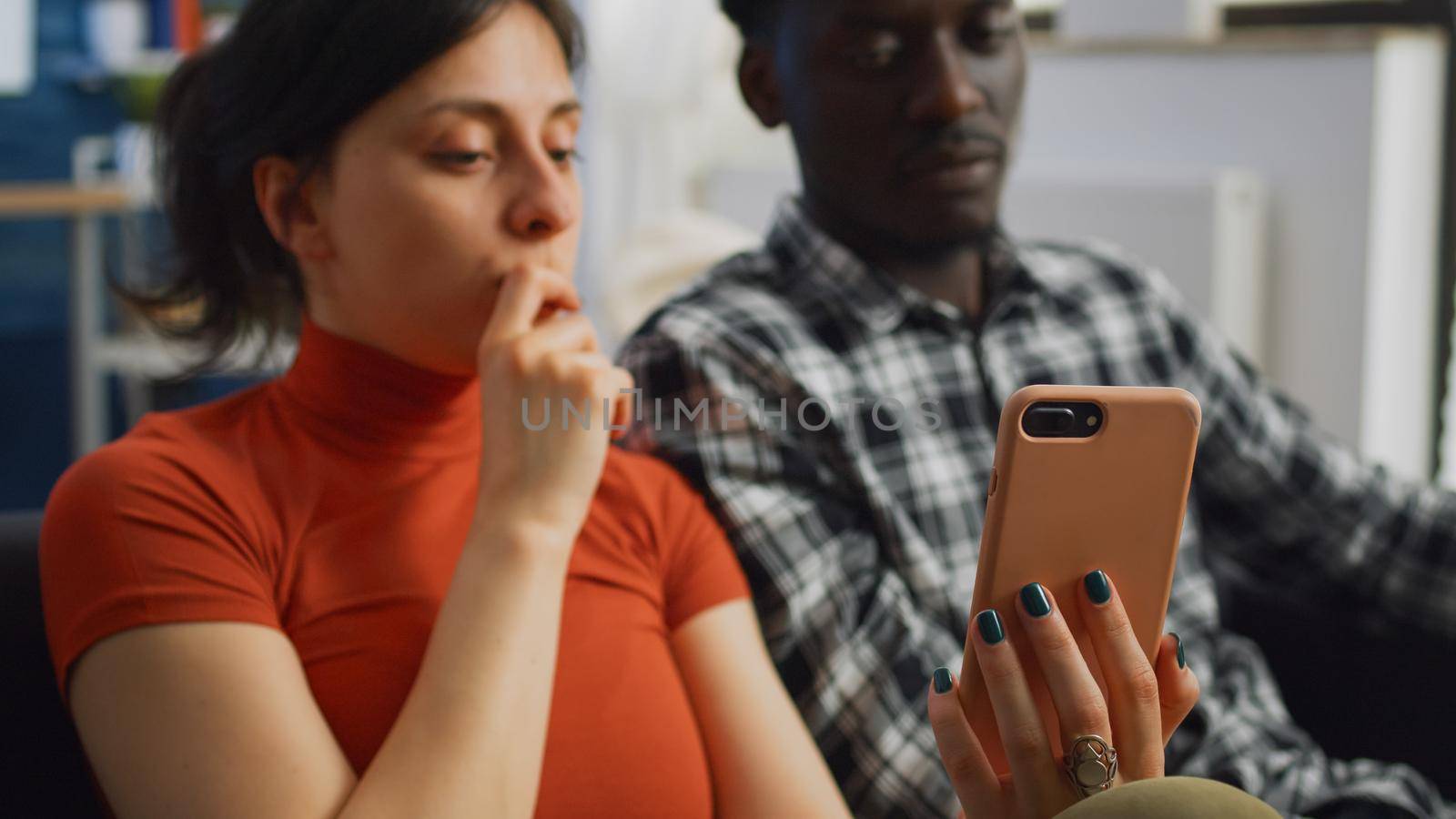 Close up of interracial couple looking at smartphone by DCStudio