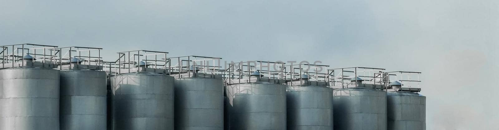 Industrial tanks for storing, receiving and preparing liquid products against a blue sky.