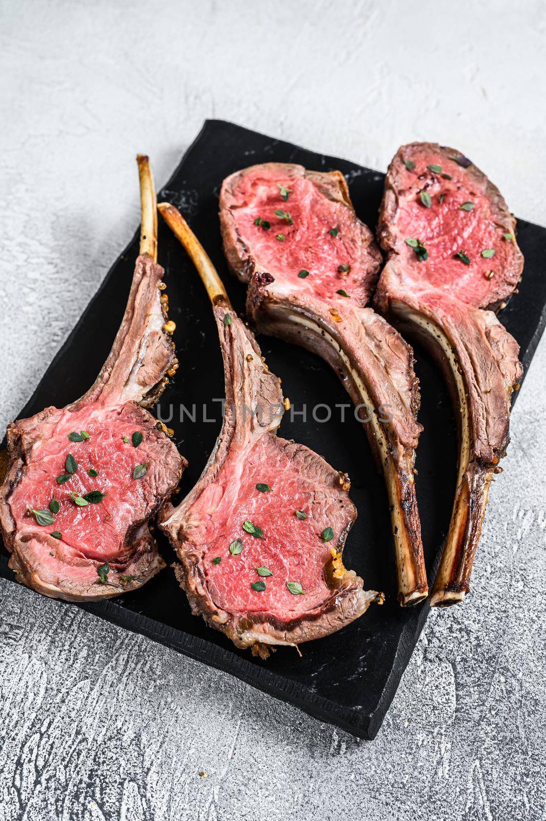 Baked lamb chop meat steaks. White background. Top view by Composter