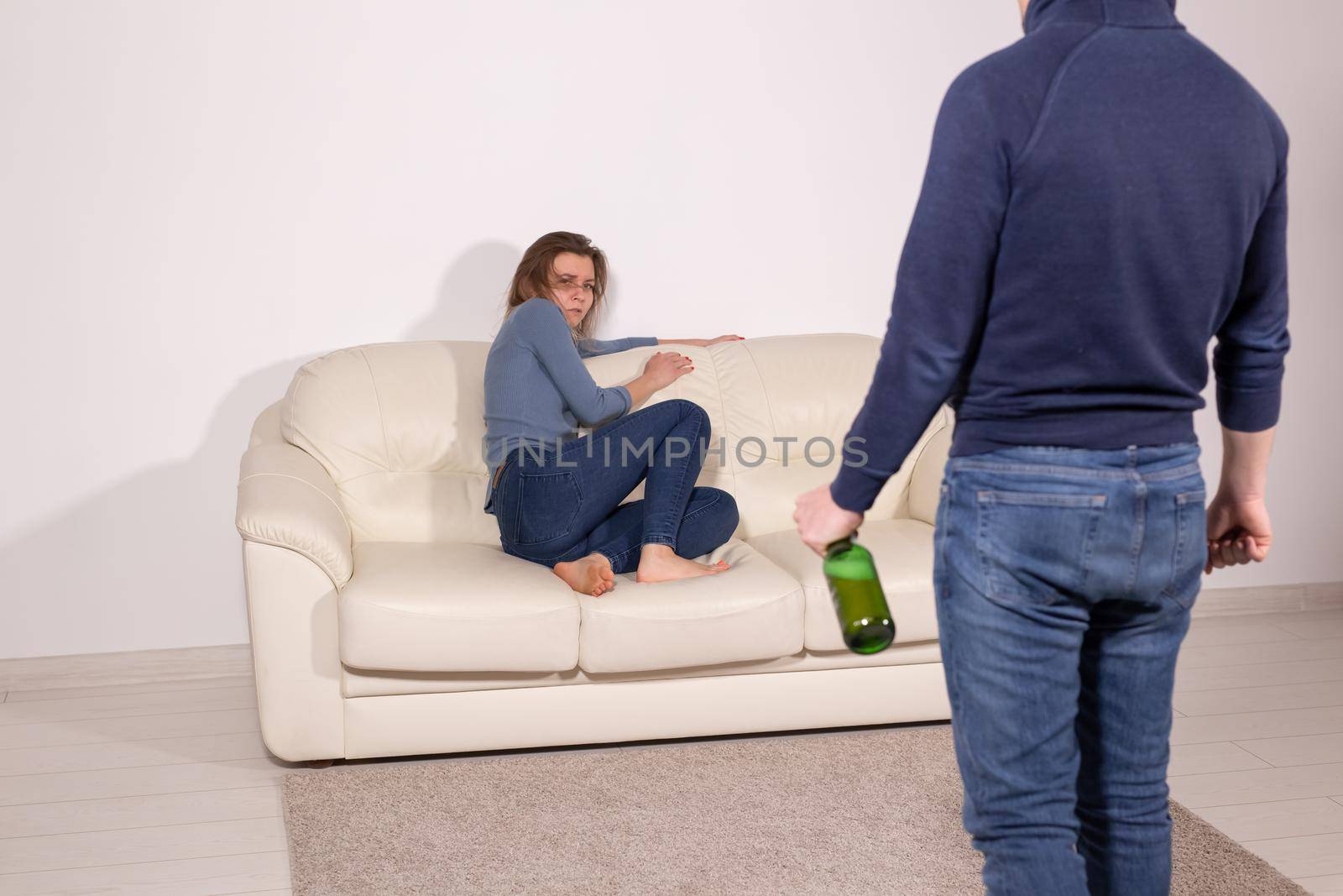 alcoholic, domestic violence and abuse concept - man gets drunk at home and takes his anger at his wife by Satura86