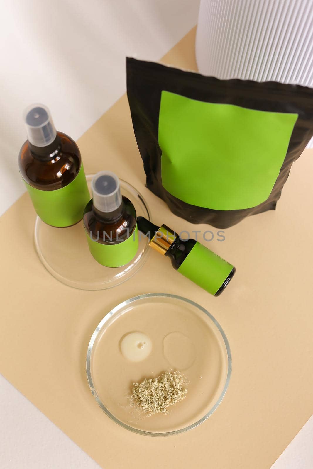 Close up doy pack and spray bottles with cosmetic product, green space for brand, clay powder and water. by sisterspro