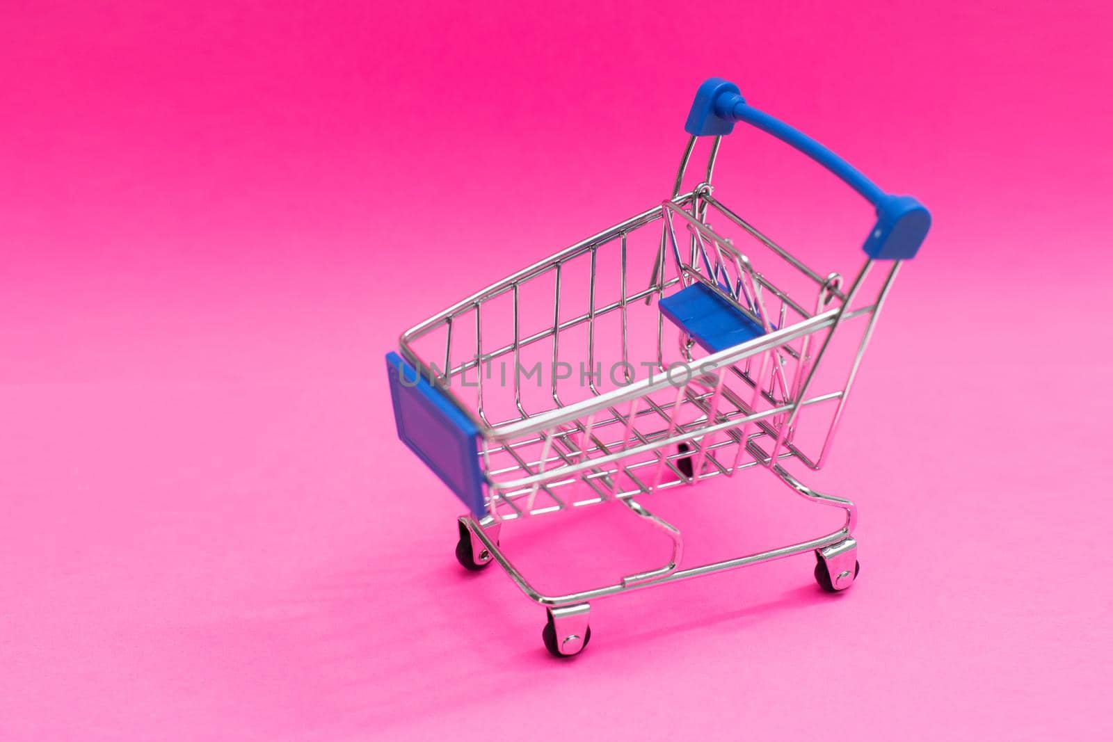 shopping cart isolated on pink background.