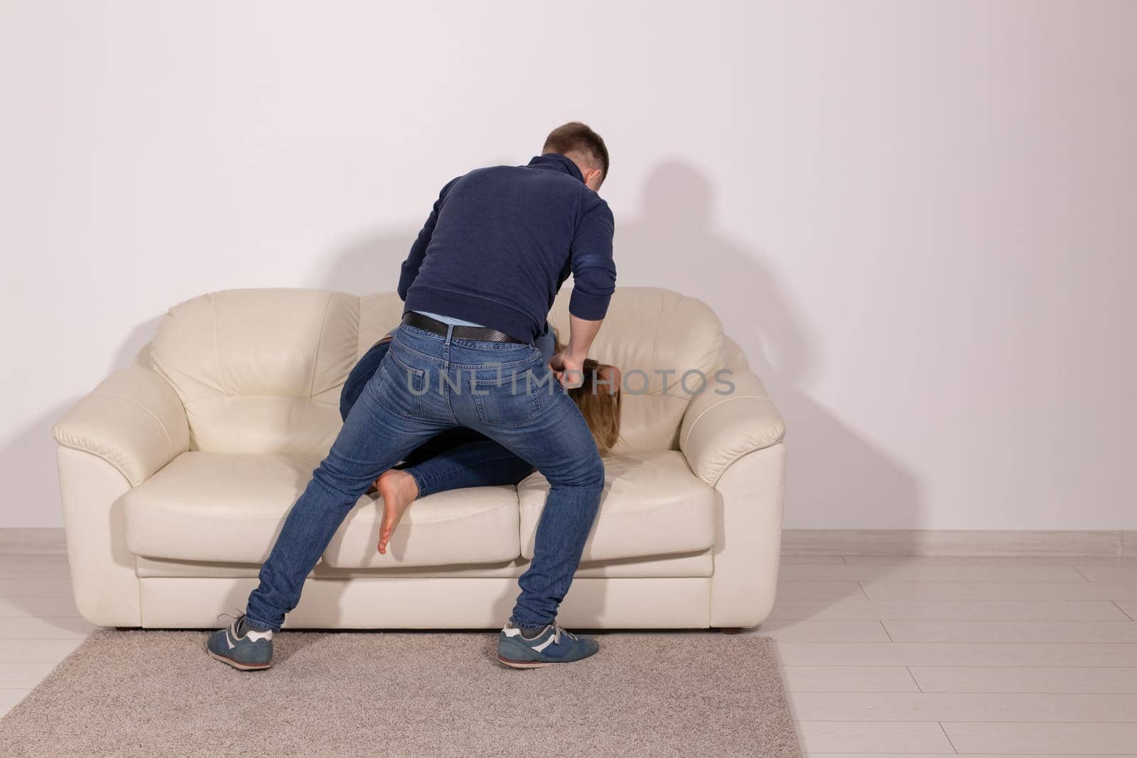 people, abuse and violence concept - aggressive man hitting his wife on sofa by Satura86