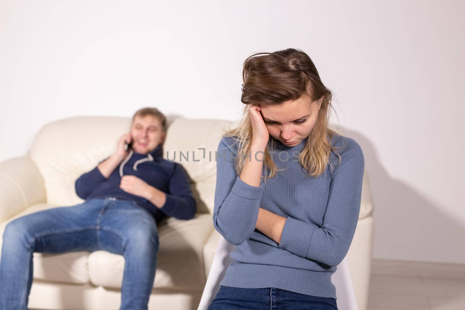 domestic violence, abuse and family concept - crying woman and her husband on the background.