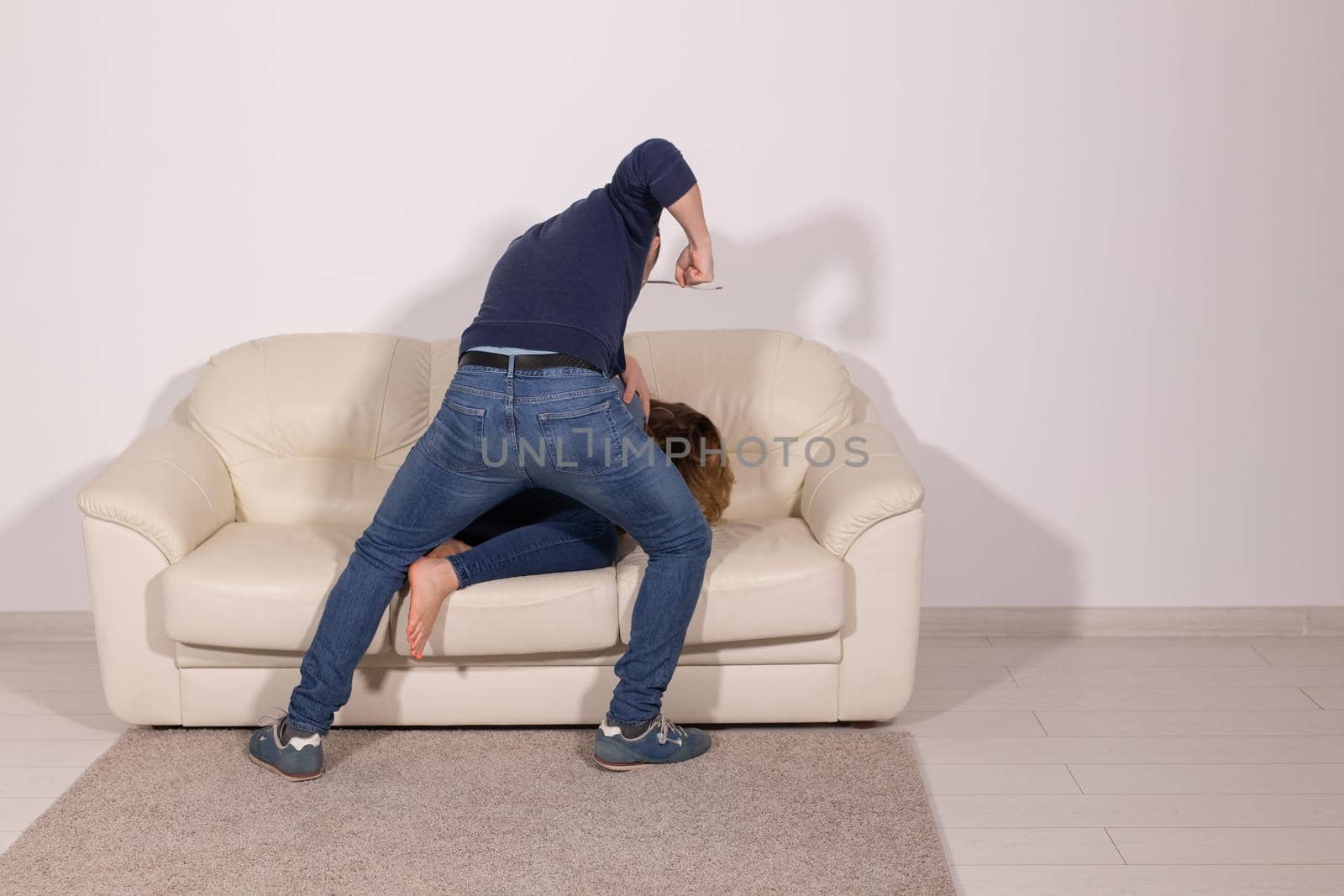 people, abuse and violence concept - aggressive man hitting his wife on sofa by Satura86