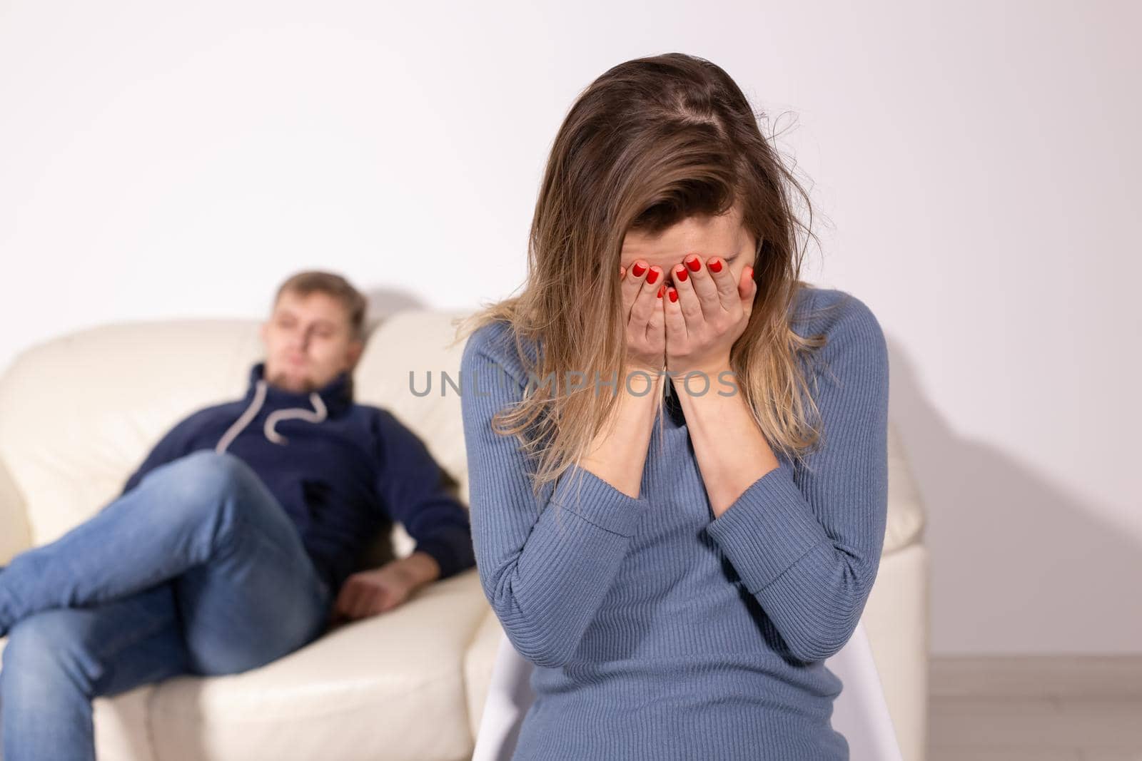 domestic violence, abuse and family concept - crying woman and her husband on the background.