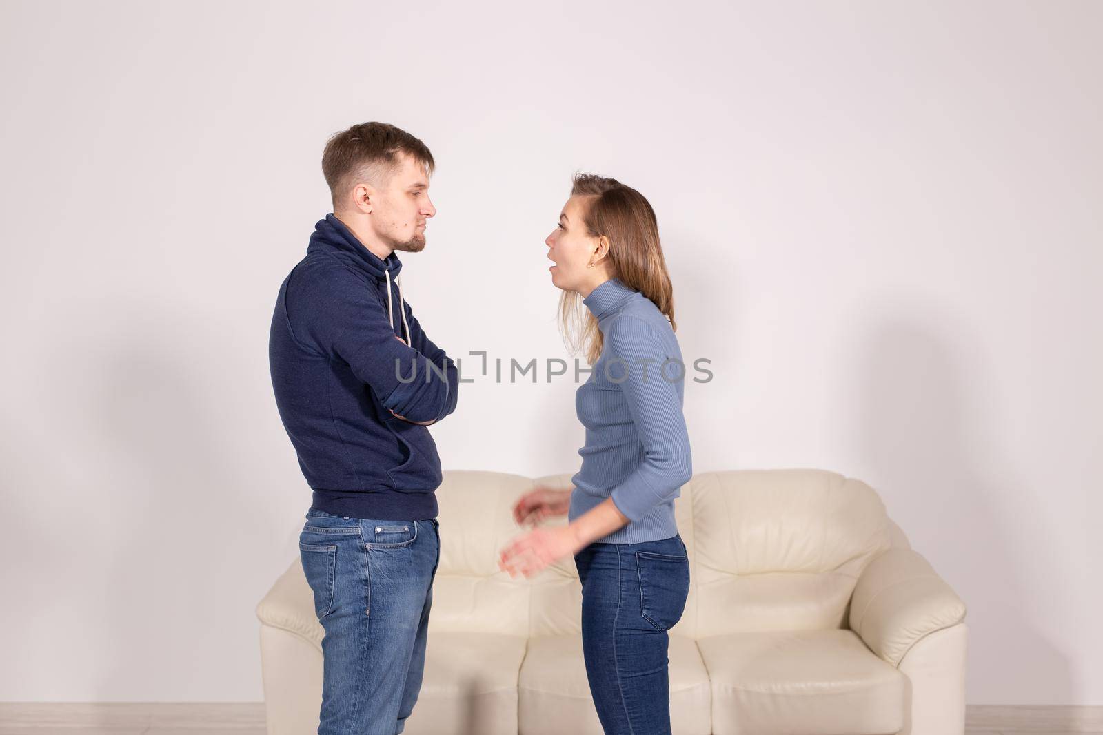 people, home violence and abuse concept - young couple screaming to each other on white background.