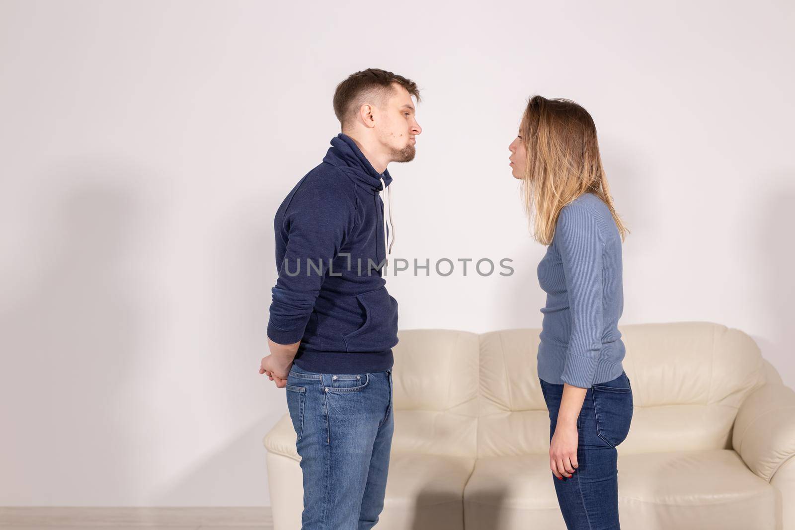 people, home violence and abuse concept - young couple screaming to each other on white background.