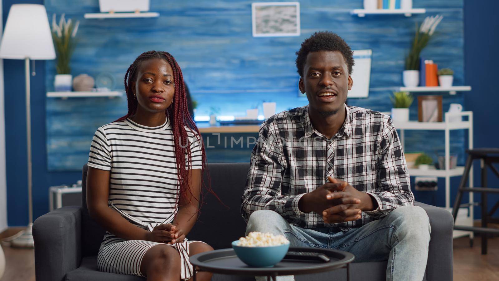 Black couple waving at camera on video call in living room. African american married people talking on online conference for remote communication at home. Partners with technology