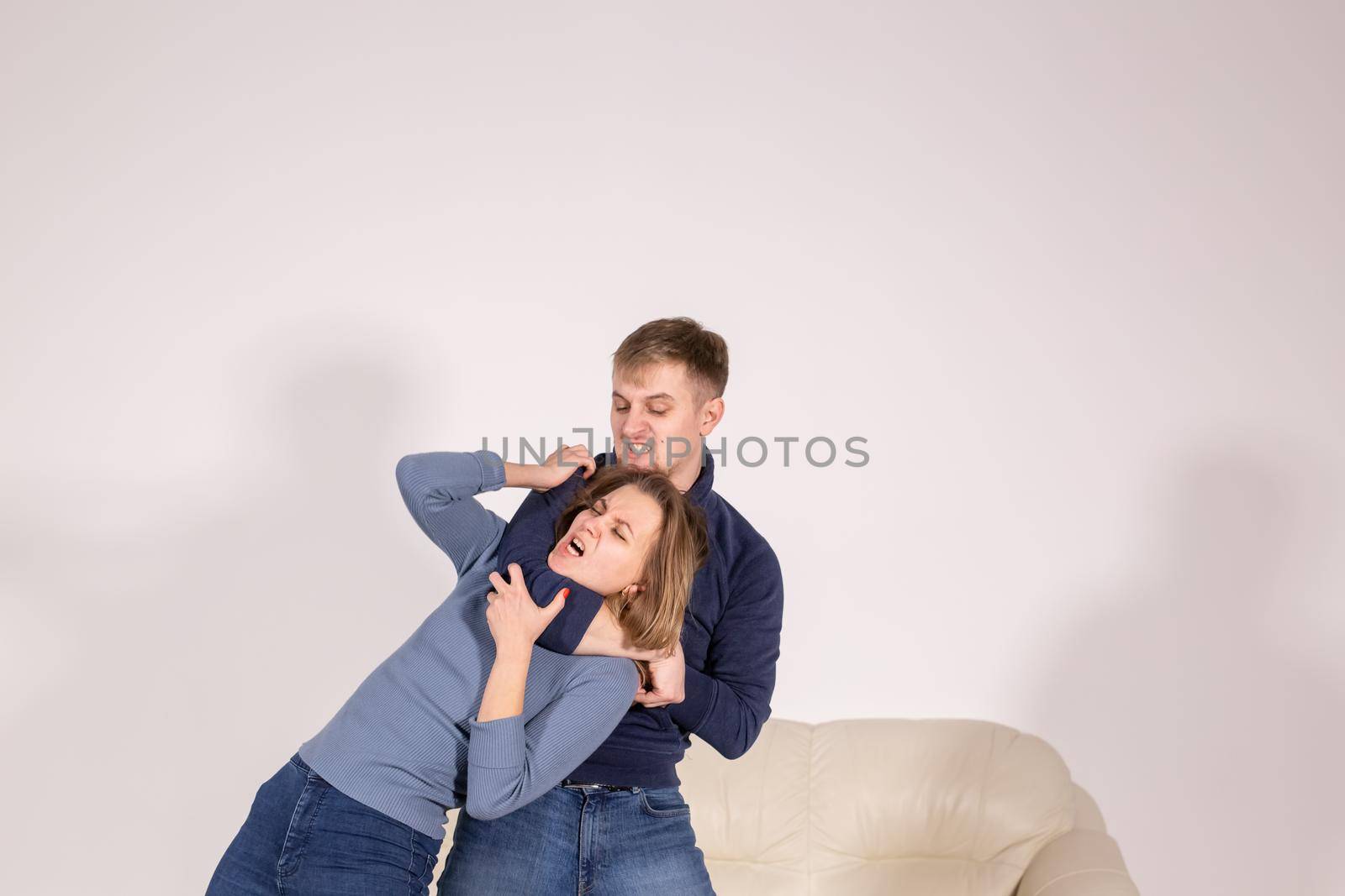 people, abuse and violence concept - agressive man strangling his wife.