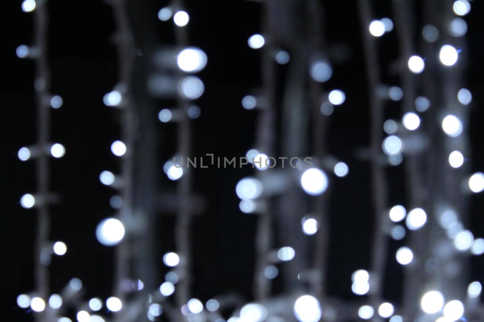 blue blue garlands on a dark black background. New Year's Eve christmas background. Festive lighting.