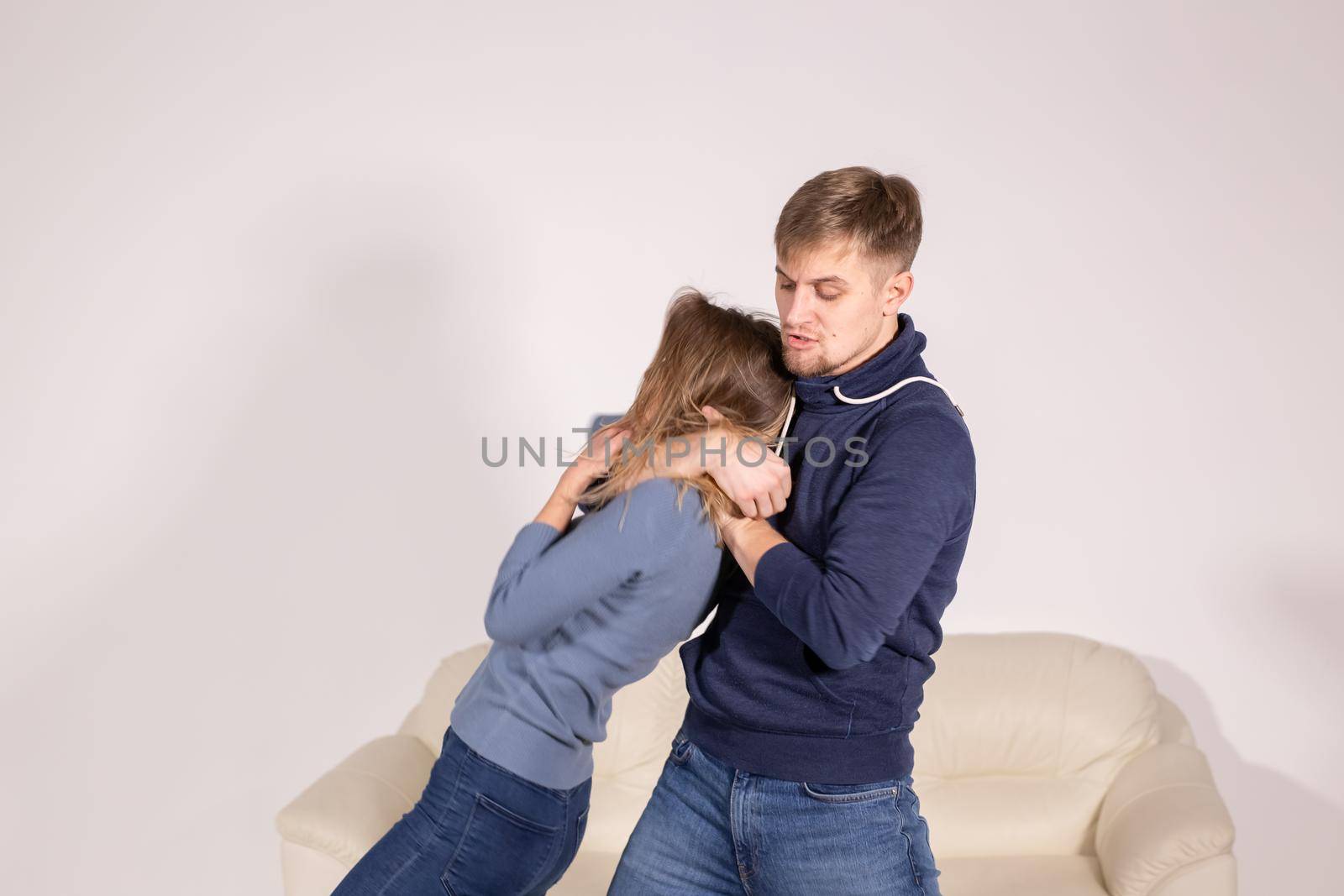 People, abuse and violence concept - aggressive man strangling his wife.