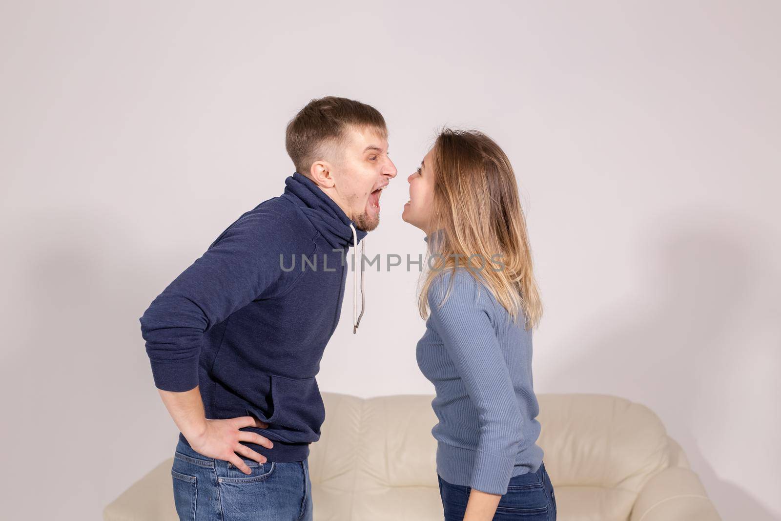 people, domestic violence and abuse concept - young couple arguing indoors by Satura86