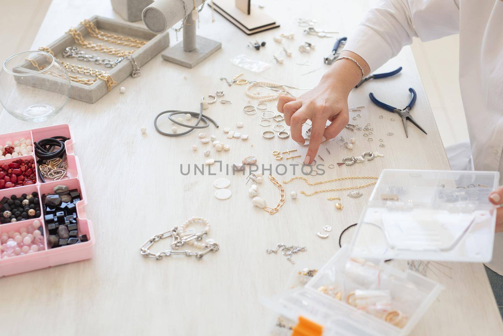 Professional jewelry designer making handmade jewelry in studio workshop. Fashion, creativity and handmade concept.
