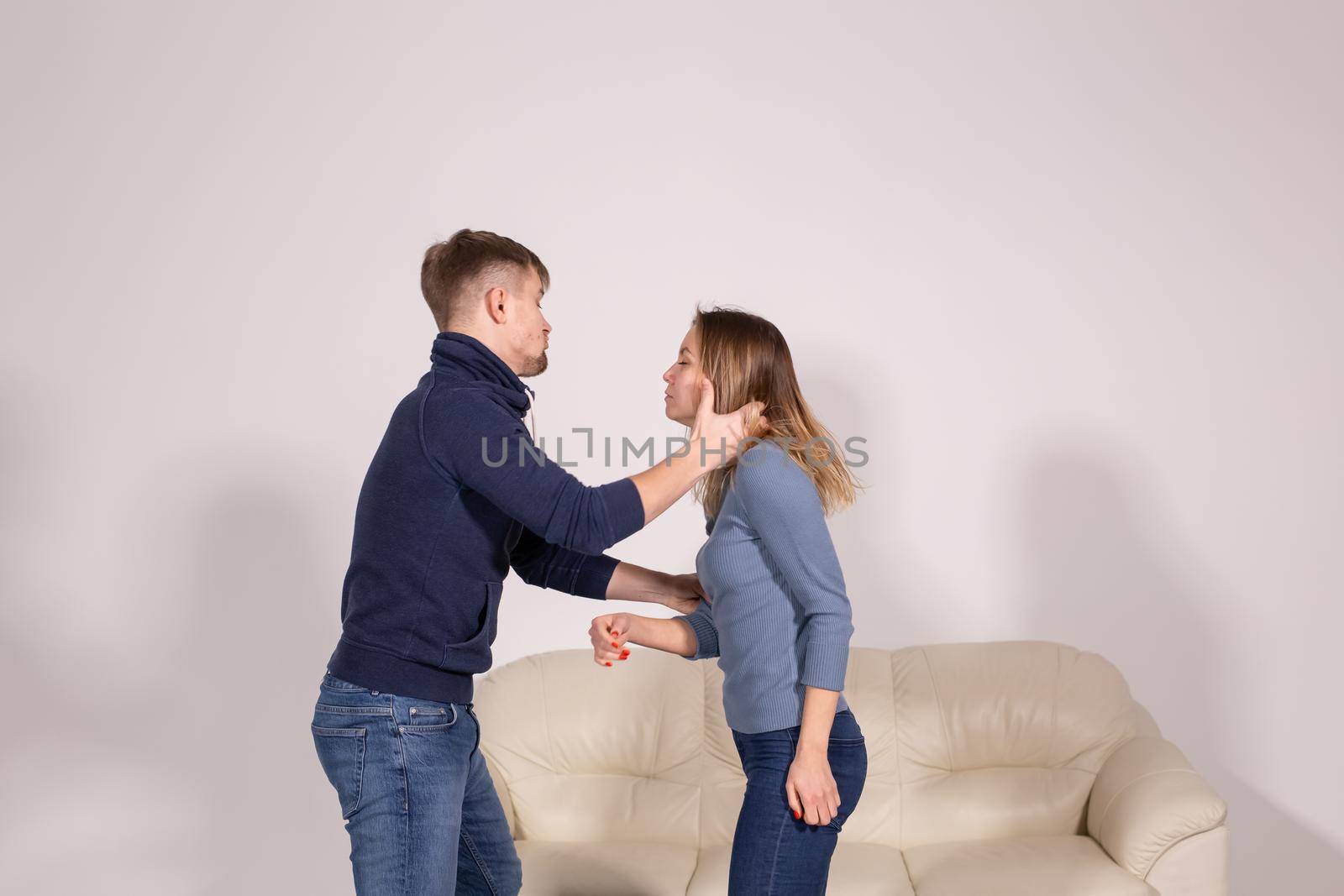 People, violence and abuse concept - man beating helpless woman at home background.