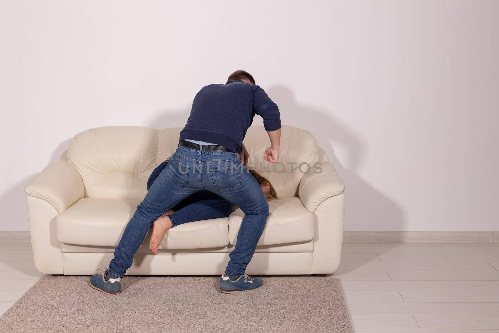 people, abuse and violence concept - aggressive man hitting his wife on sofa by Satura86