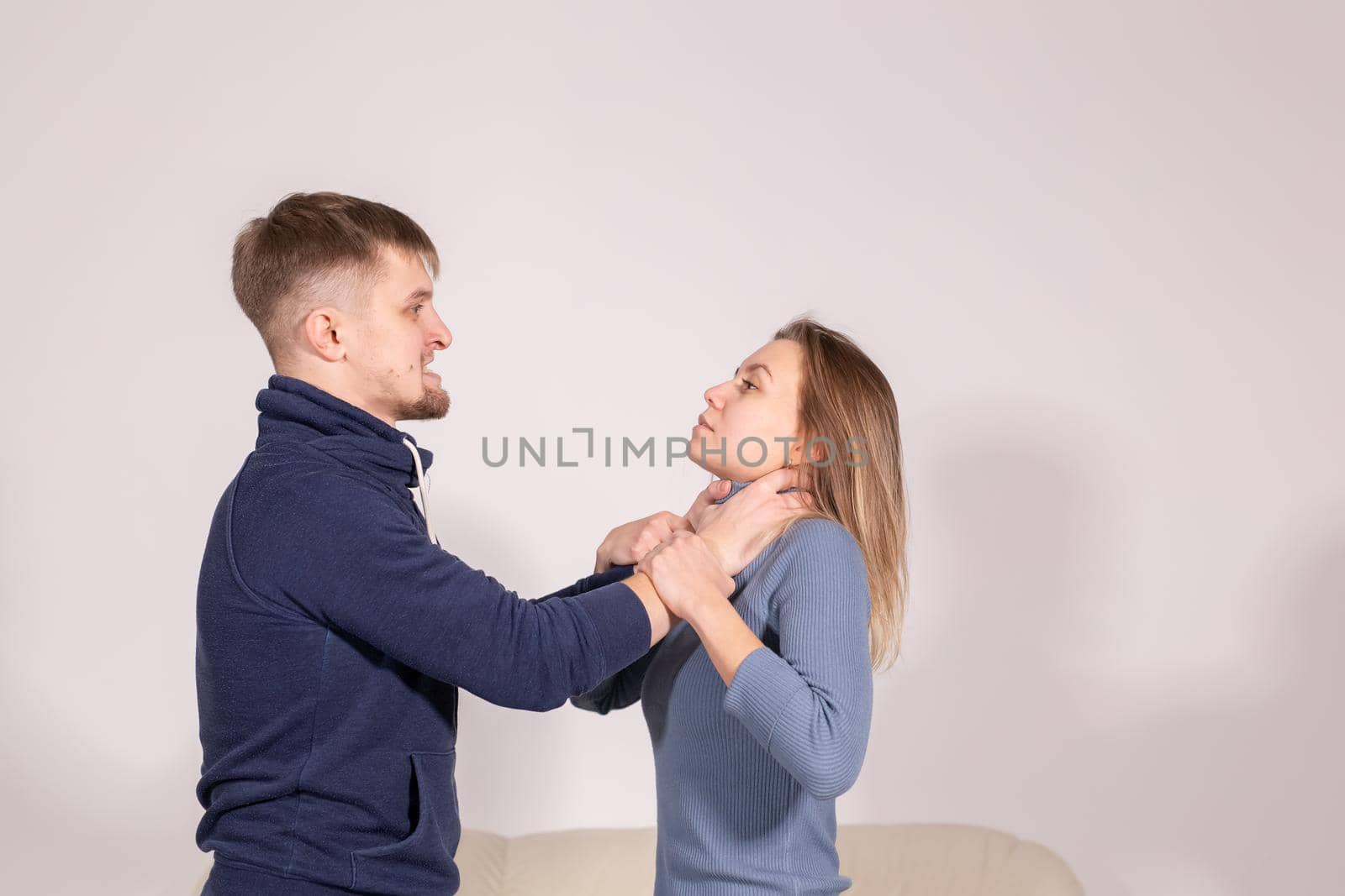 people, domestic violence and abuse concept - young man choked his wife on white background by Satura86