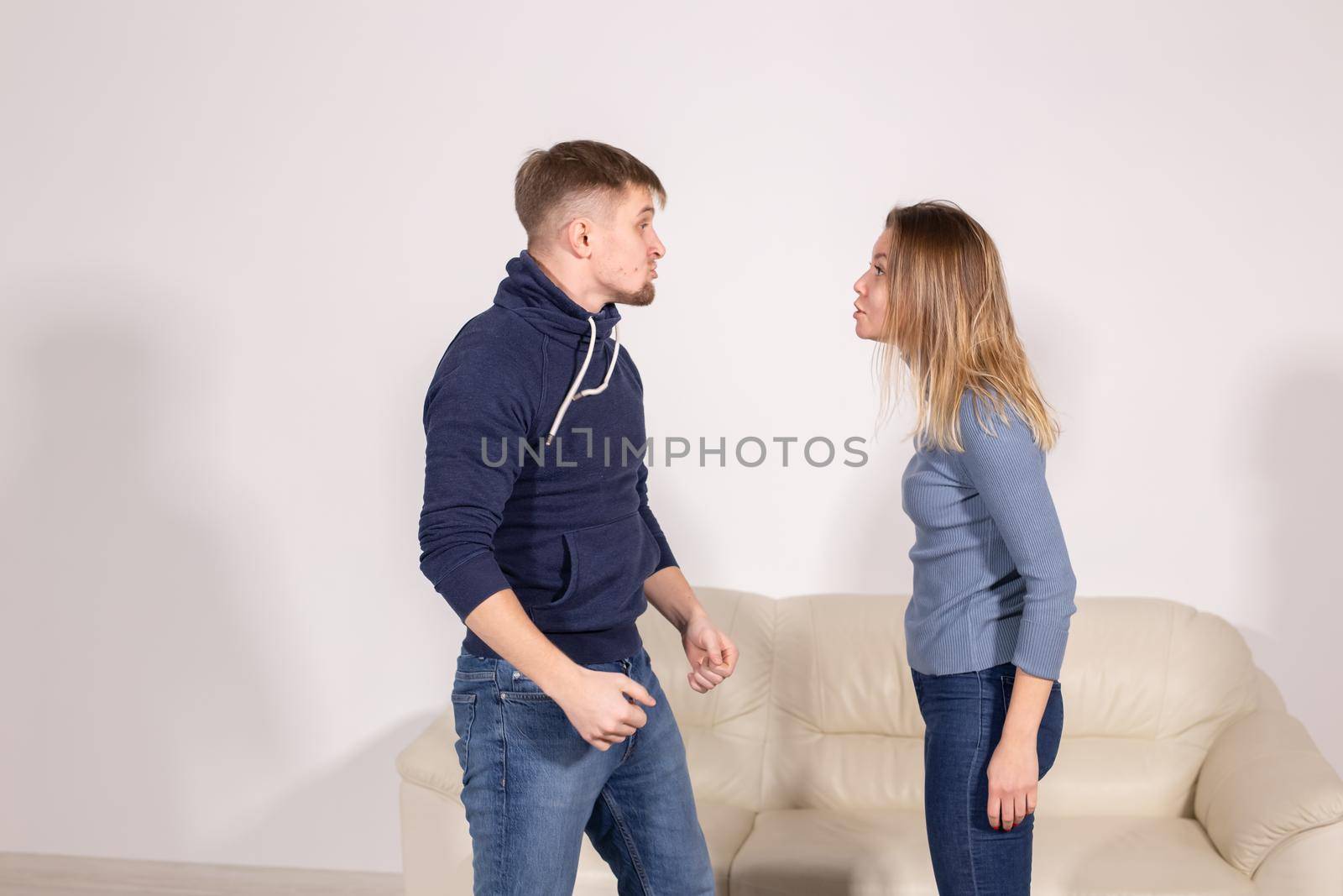 people, home violence and abuse concept - young couple screaming to each other on white background.