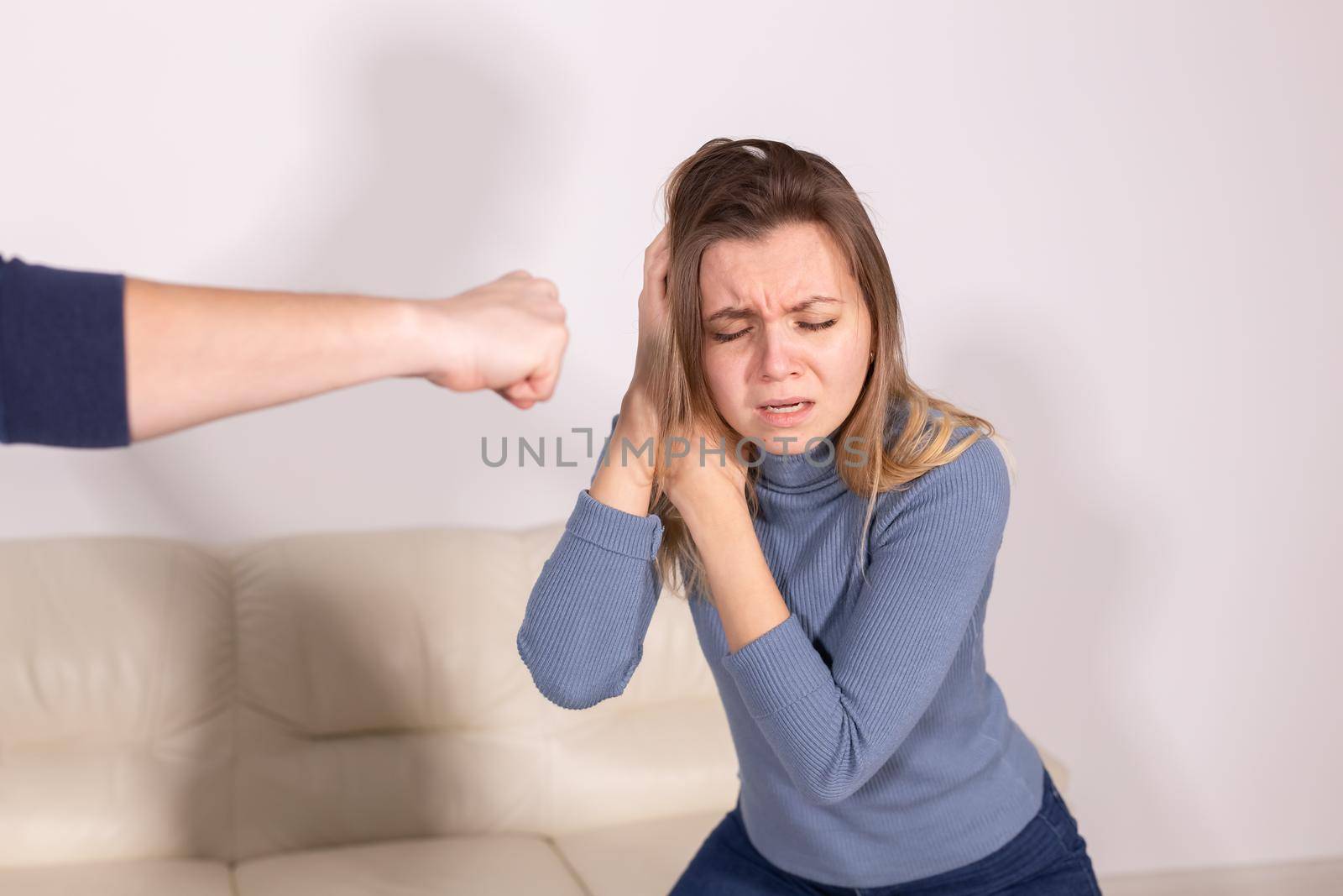 People, violence and abuse concept - man beating helpless woman at home background.