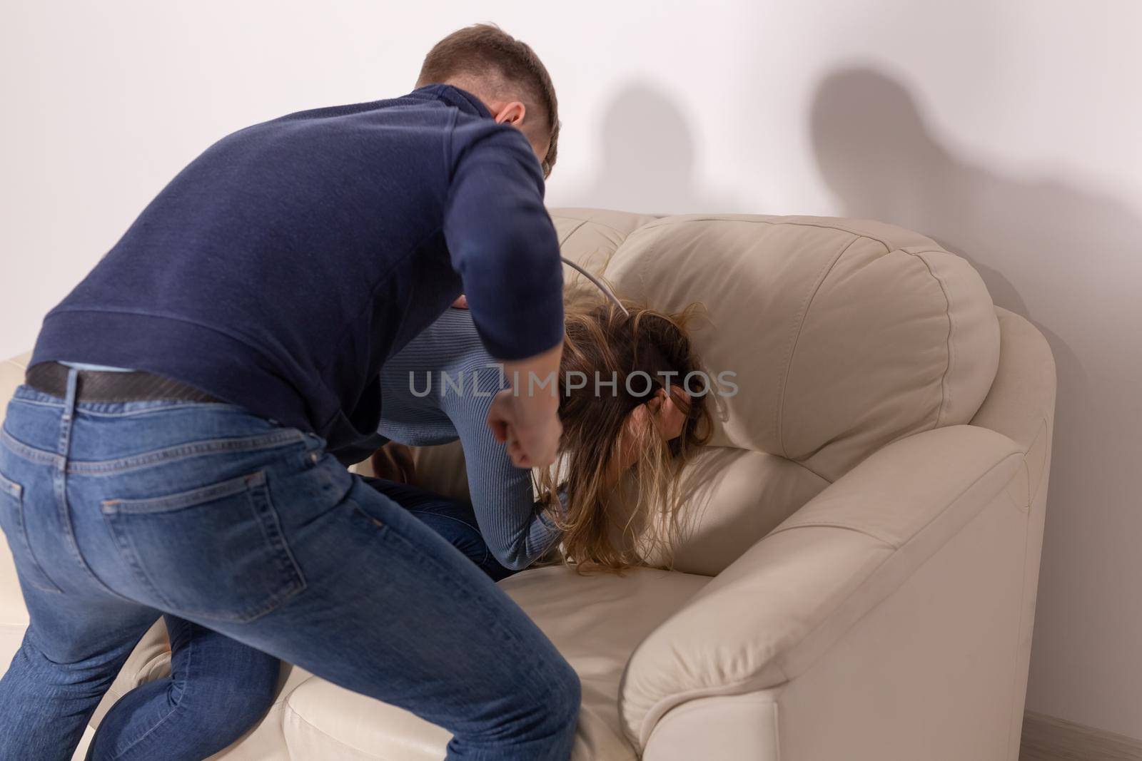 people, domestic violence and abuse concept - young man threatens his wife with his fist on white background by Satura86