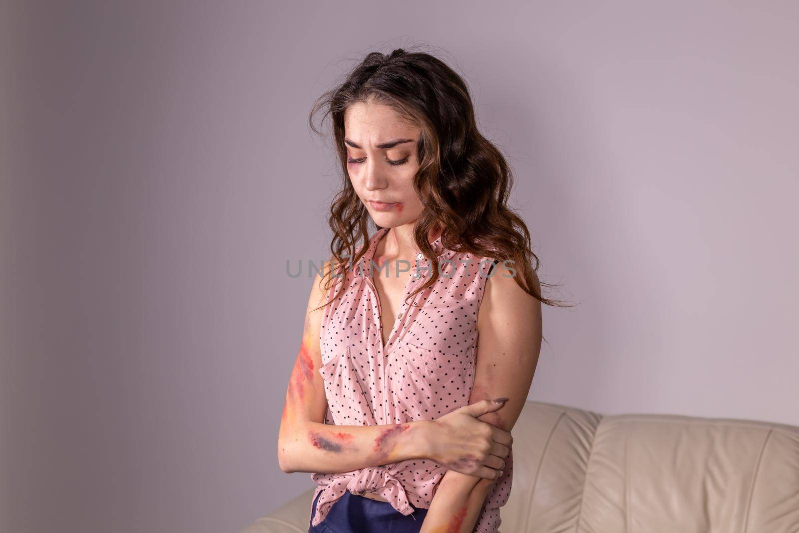 violence issues - Woman victim of domestic violence and abuse over grey background.